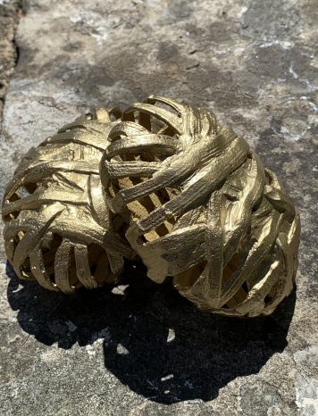Two Gold Coloured Decorative Items Shaped like Twine