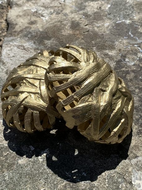 Two Gold Coloured Decorative Items Shaped like Twine